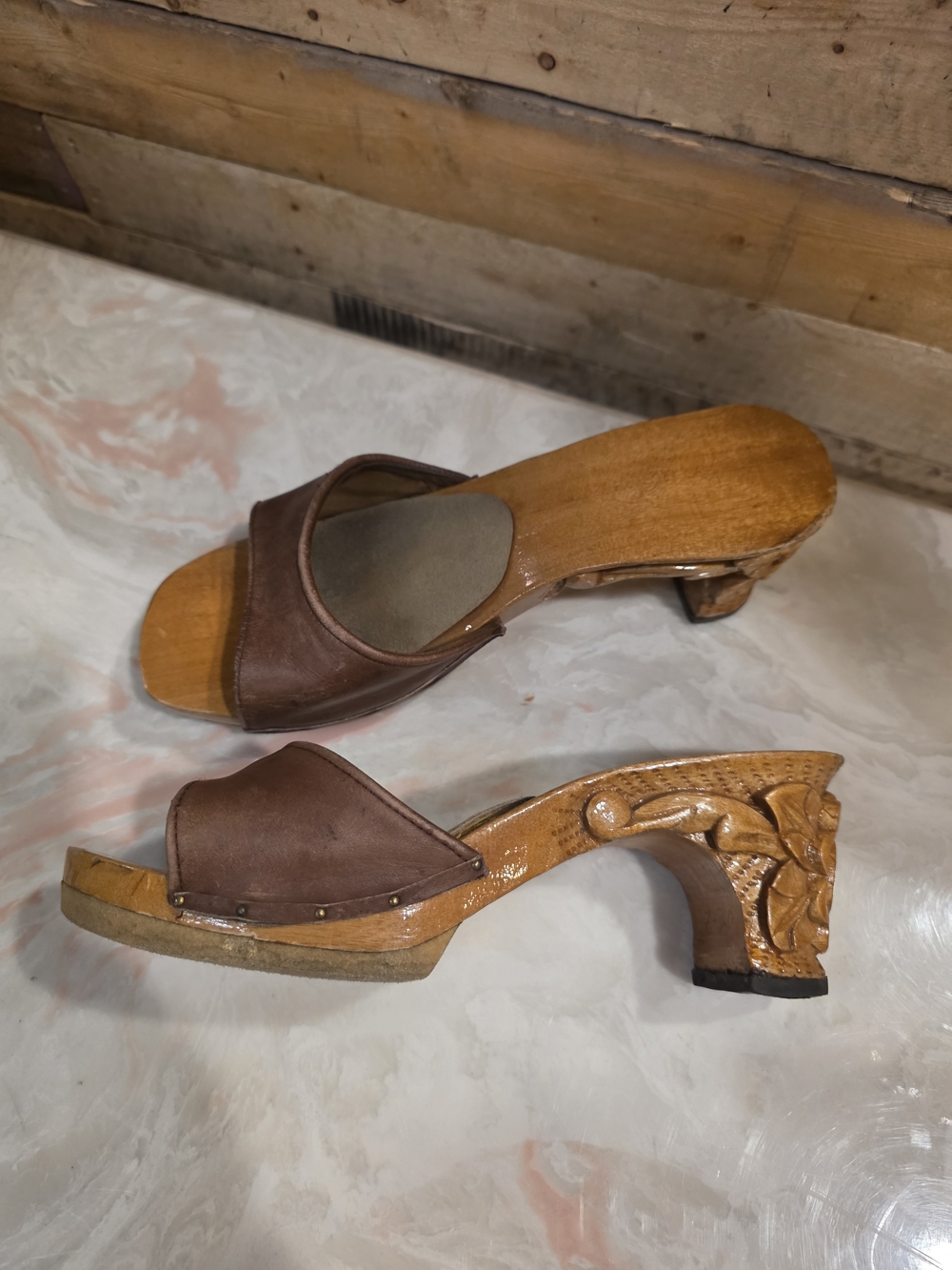 Vintage-inspired handmade leather sandals with intricately carved wooden heels.